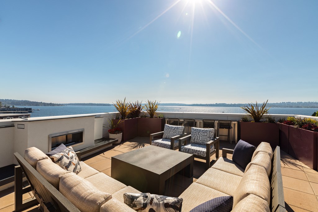 Vela Apartments  terrace with a couch and chairs overlooking  water