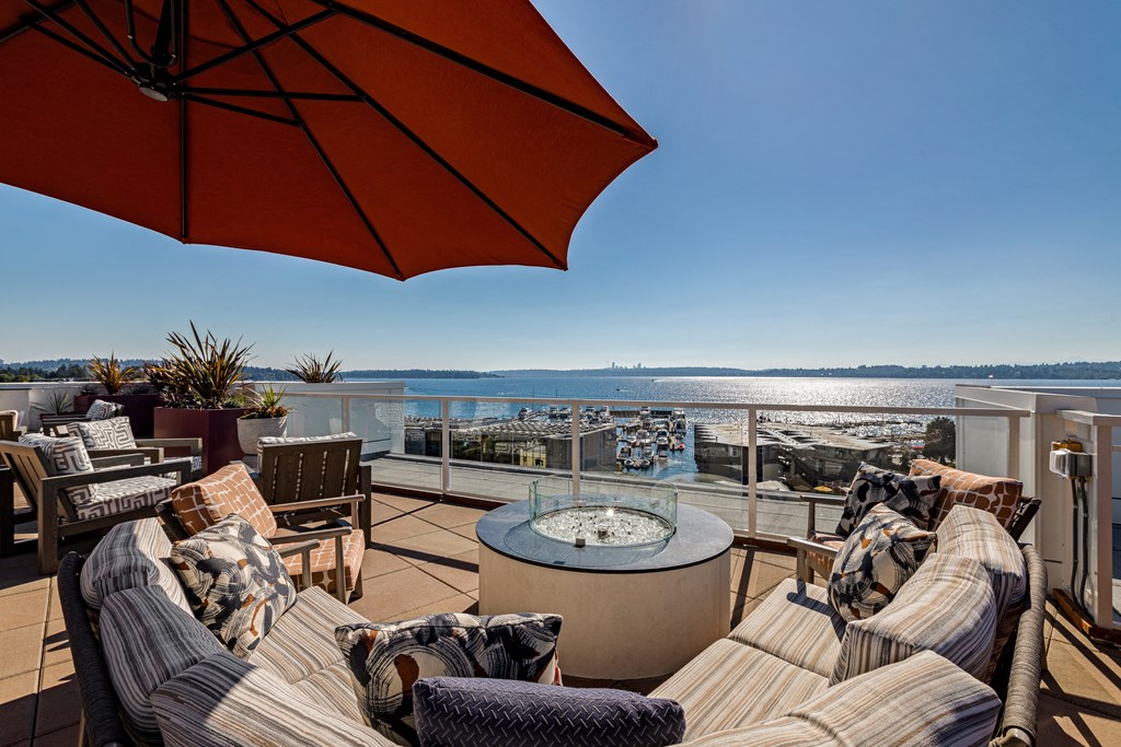 Vela Apartments  seating area with a fire pit and a view of the water