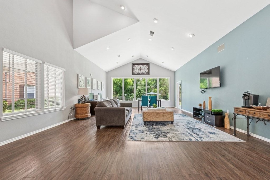 A spacious living room with a grey sofa and a wooden coffee table.