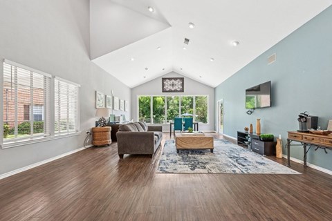 A spacious living room with a grey sofa and a wooden coffee table.