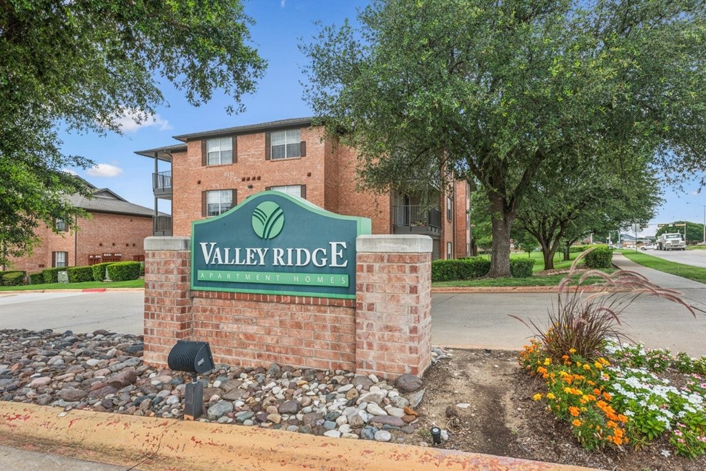 A brick sign that says Valley Ridge in front of a building.