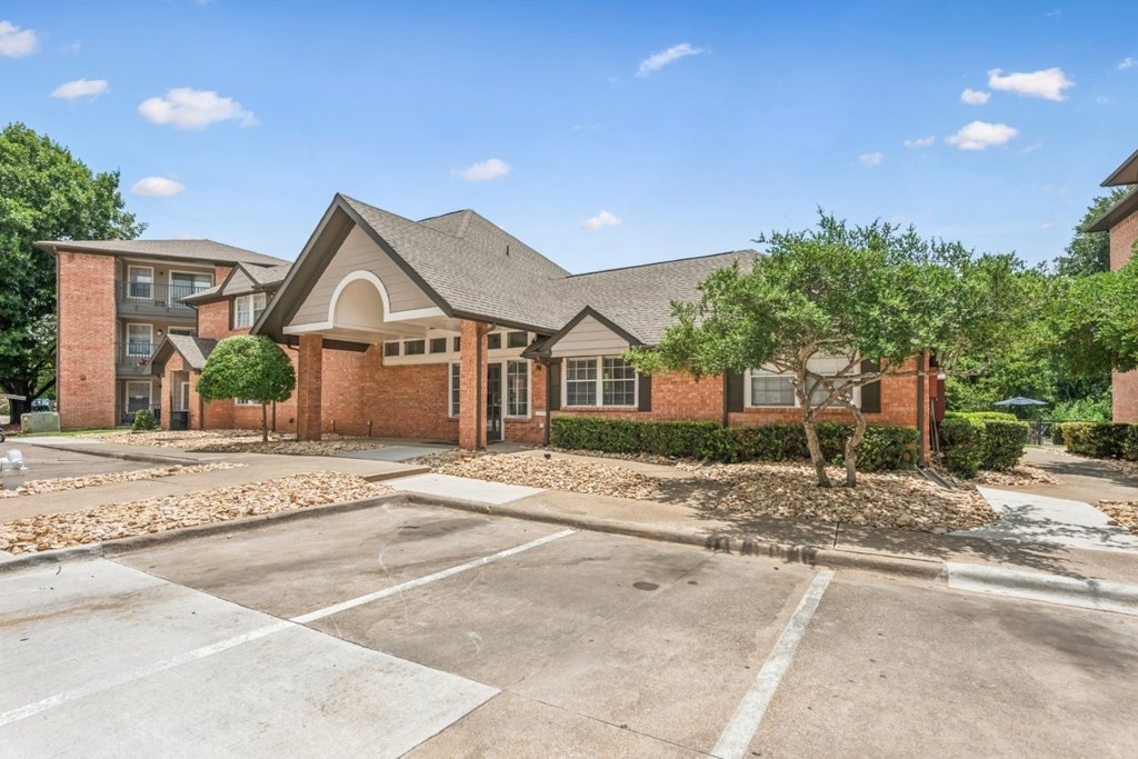 A large brick building with a parking lot in front.