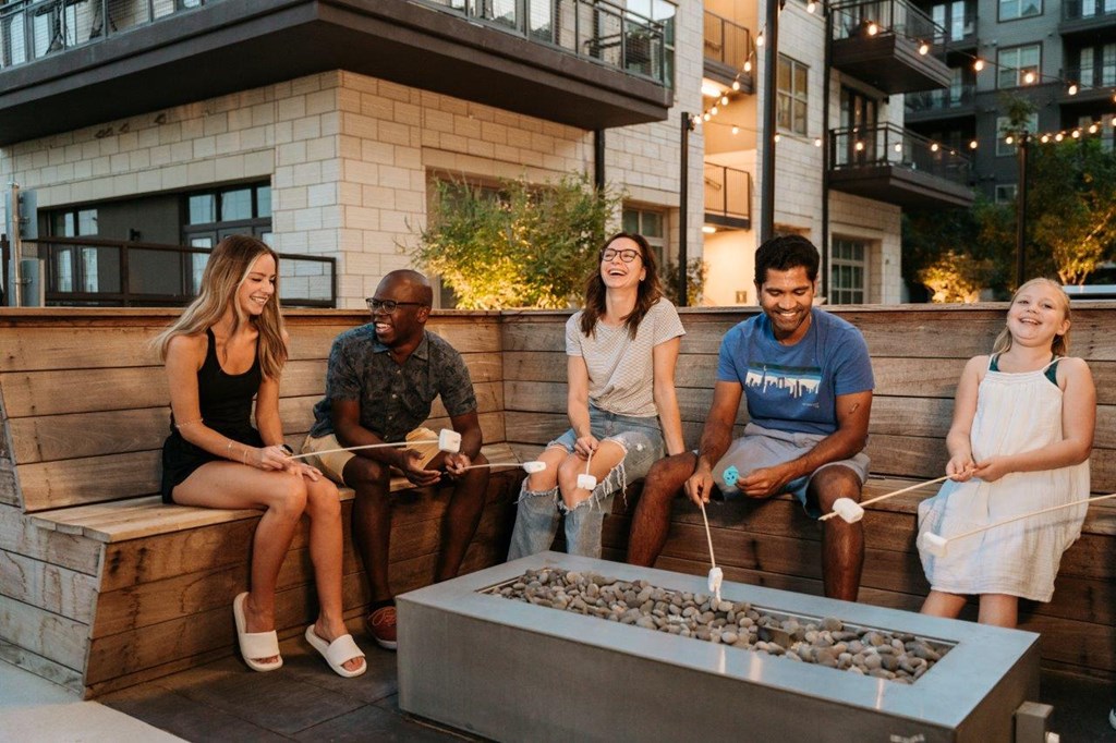 Friends Sitting Around Fire Pit Together at Valor at the Realm in Lewisville, Texas