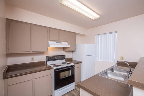 A kitchen with a stove, oven, and sink.