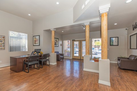 A living room with a brown couch and a wooden floor.