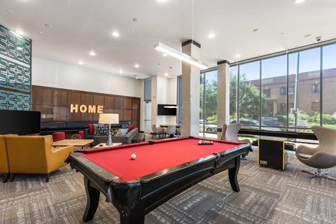 A pool table in a room with a sign that says "HOME".