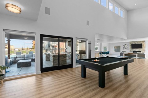 a living room with a pool table in the middle of it