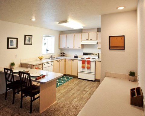 A kitchen with a table and chairs.