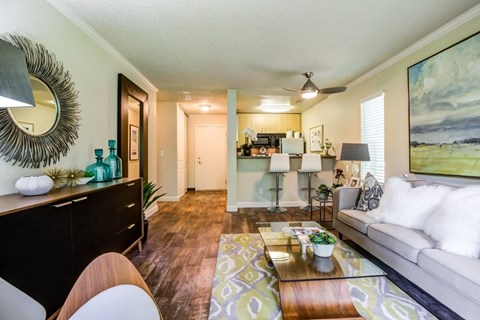 A living room with a couch, coffee table, and a painting on the wall.