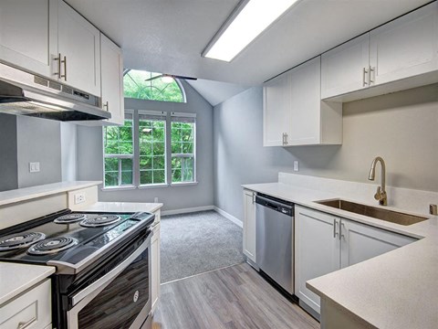 a kitchen with white cabinets and a stove and a sink