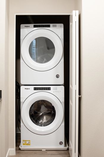 a washer and dryer sit in a closet next to a door