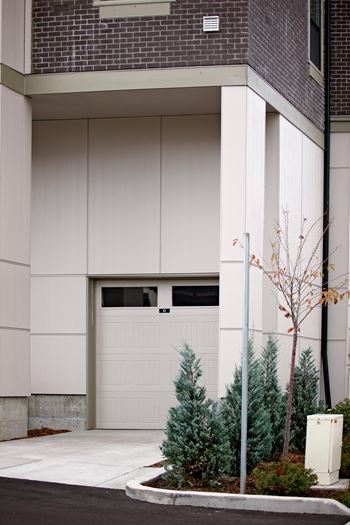 a house with a garage and trees in front of it