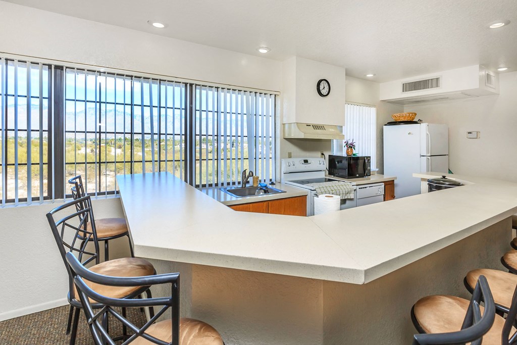A kitchen with a large island and chairs.