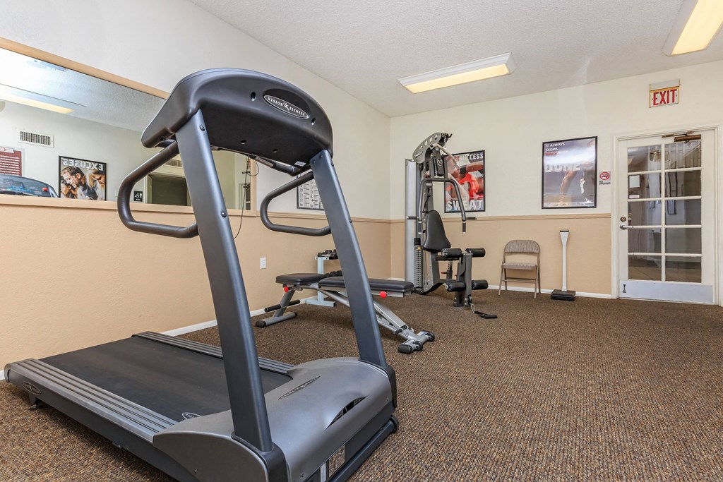 A treadmill is in a gym with other exercise equipment.