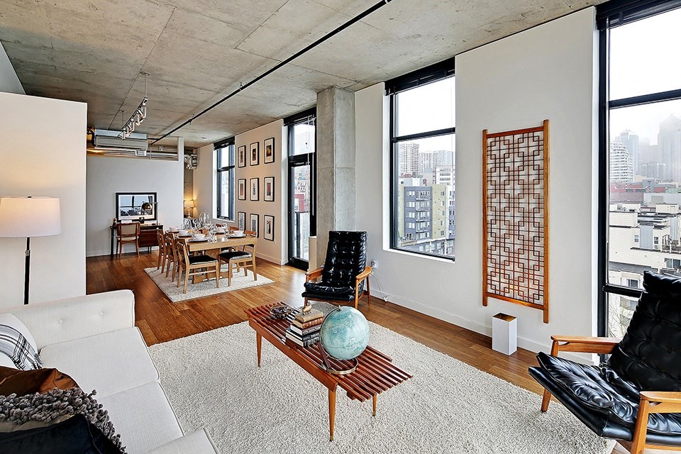 an open living room and dining room with a view of the city