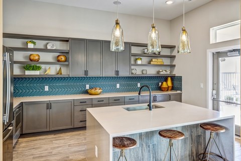 A kitchen with a white counter top and wooden bar stools.