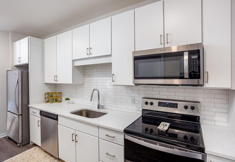 a kitchen with white cabinets and a stove and a microwave