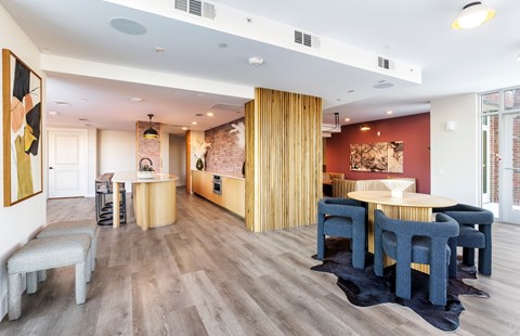 A modern dining room with a wooden floor and a large table surrounded by chairs.