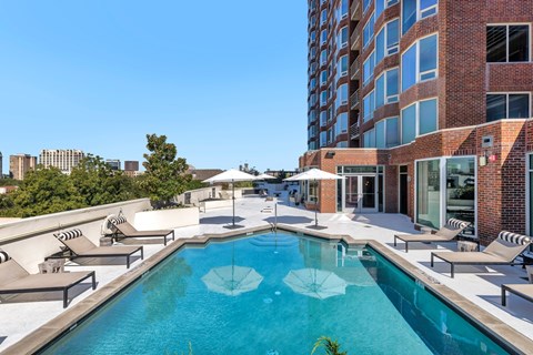 A swimming pool with a white umbrella in the middle of it.