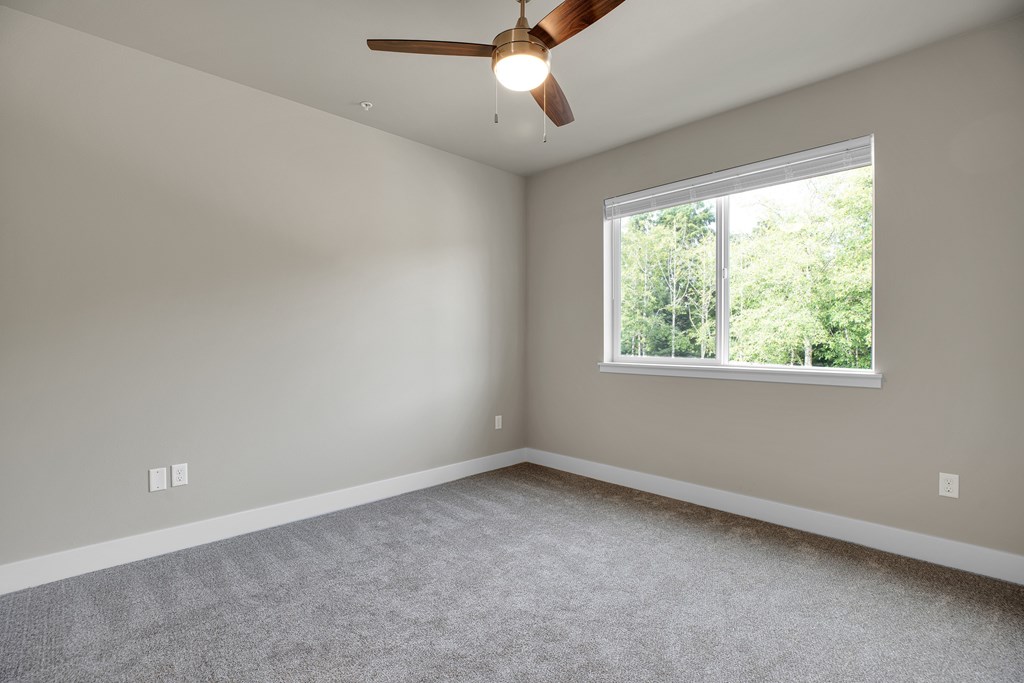 A room with a ceiling fan and a window.
