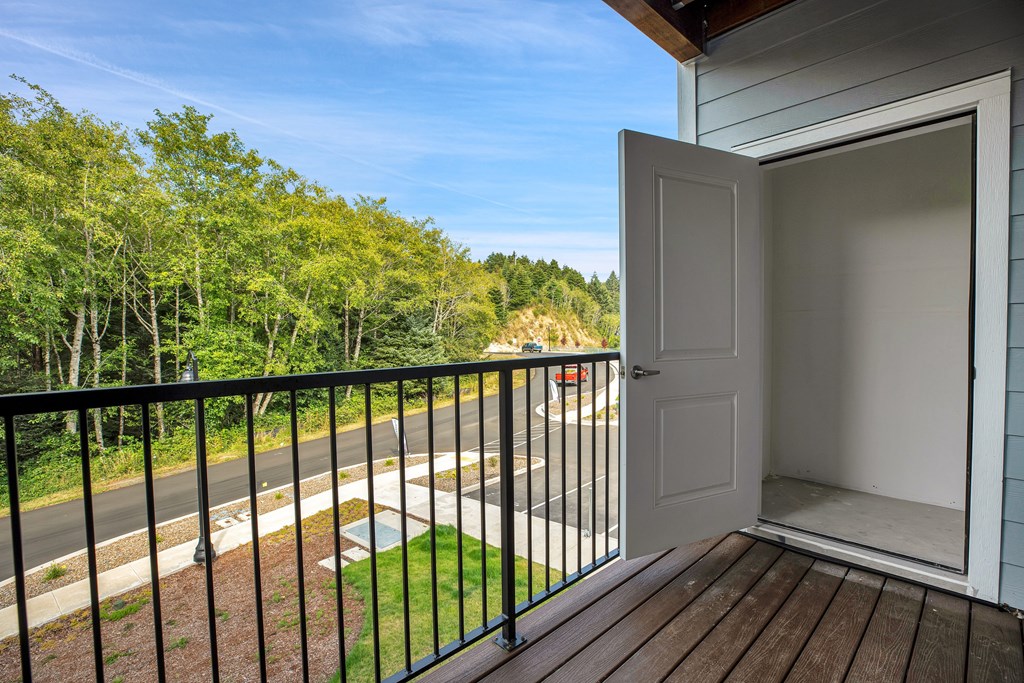 A balcony with a white door and a black railing.