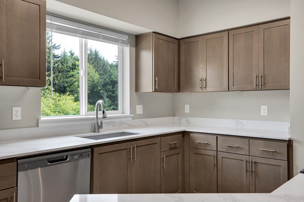 A kitchen with brown cabinets and a stainless steel dishwasher.