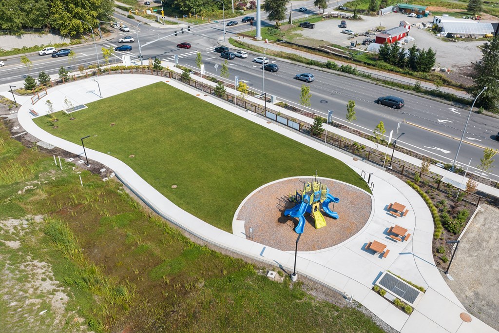 A playground with a blue and yellow structure in the middle of a green field.