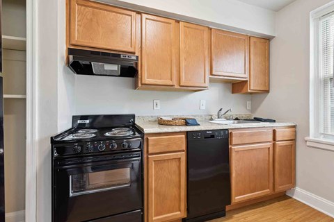A kitchen with wooden cabinets and black appliances.