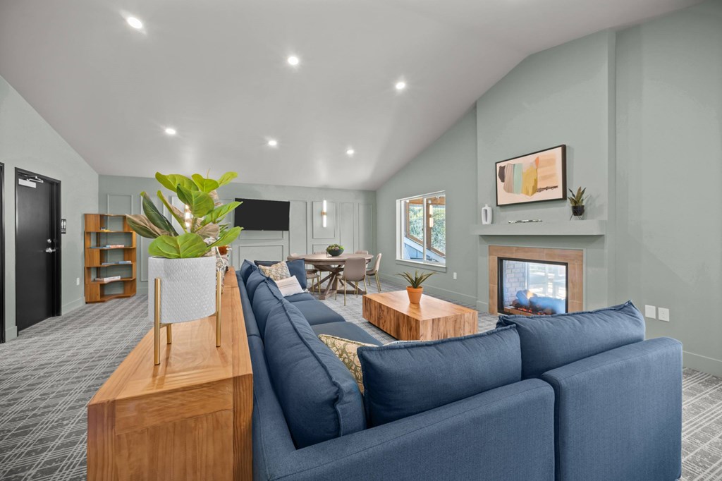 A living room with a blue couch and a wooden table.