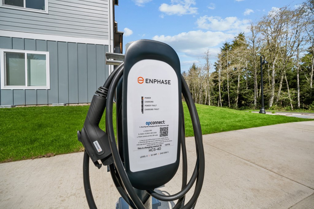 A charging station for electric vehicles is shown in front of a house.