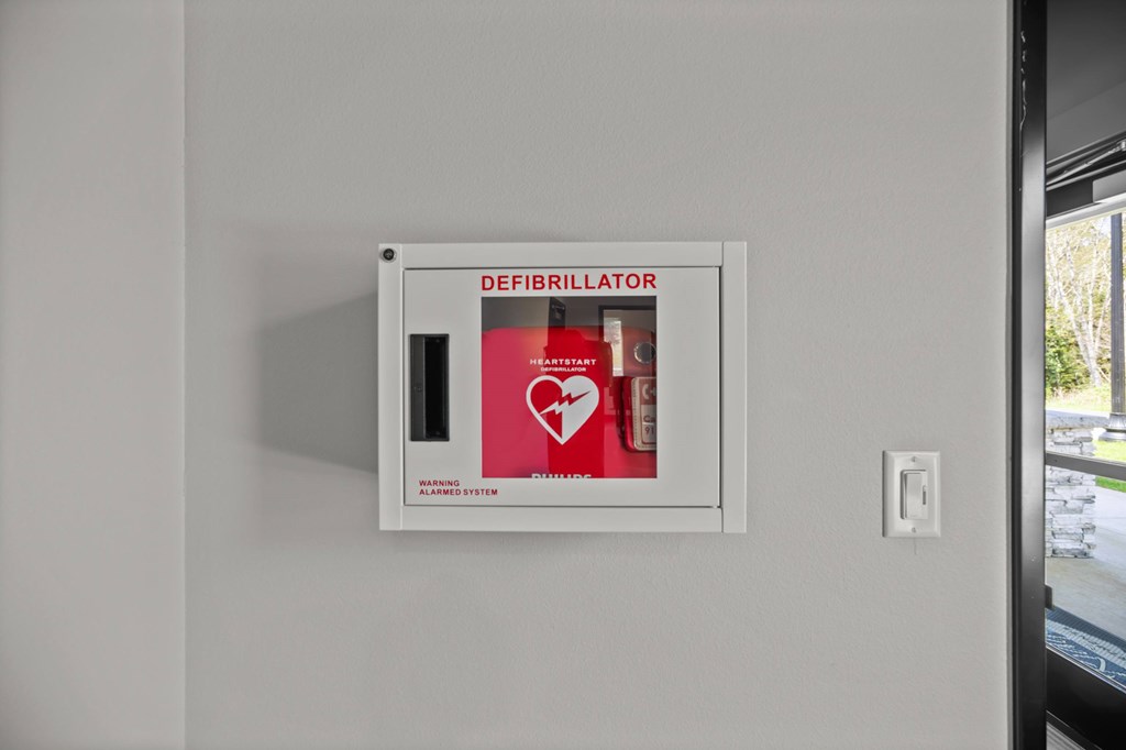 A defibrillator box is mounted on a wall.