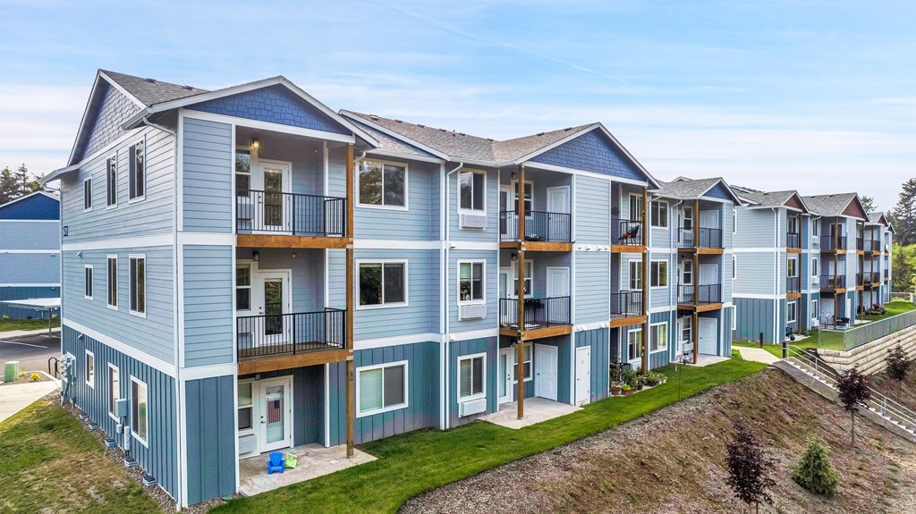 A row of blue and grey townhouses with white doors and windows.