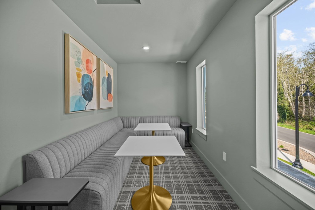 A grey couch with a white table in front of it.