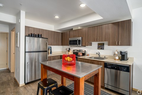 A kitchen with a stainless steel refrigerator, microwave, and dishwasher.