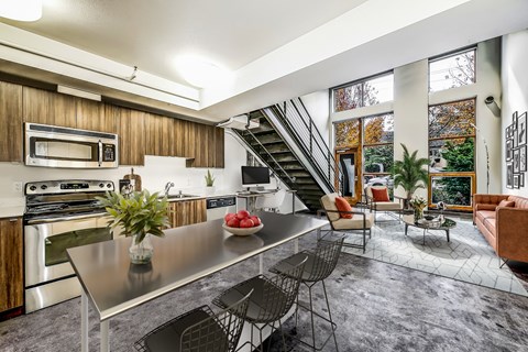 A modern kitchen with a stainless steel table and chairs.