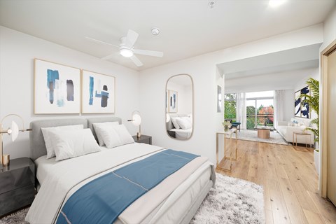 A bedroom with a large bed and a ceiling fan.