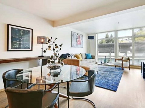 A modern living room with a glass table and chairs.