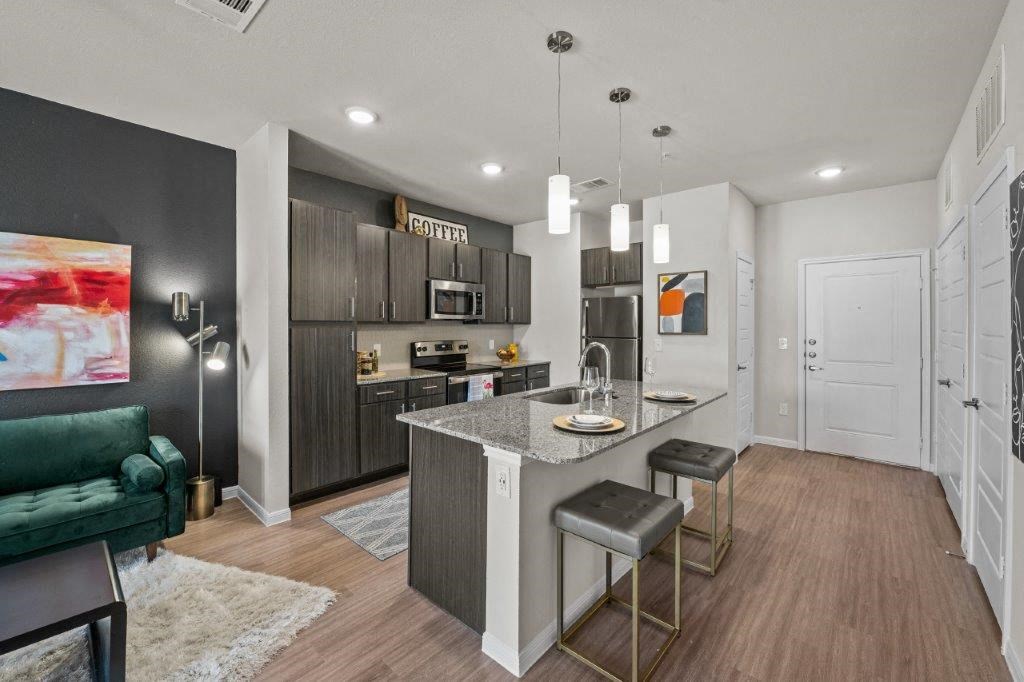 a kitchen and living room with a marble counter top