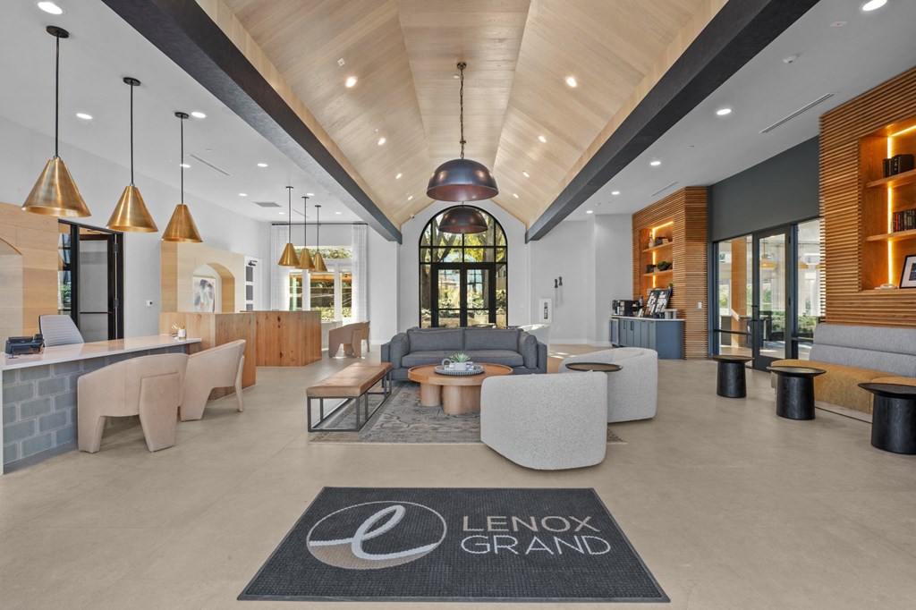 a lobby with couches and chairs and a lobby rug in front of a building