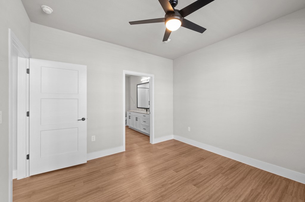 a living room with white walls and a ceiling fan