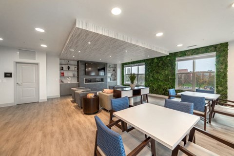 a dining room with tables and chairs and a kitchen with a green wall