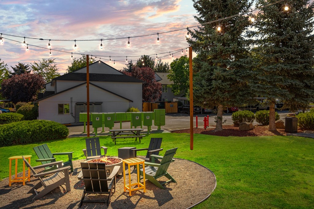A backyard with a fire pit and chairs.