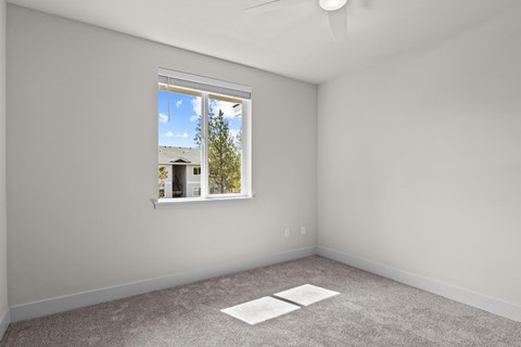 A room with a window and a fan on the ceiling.