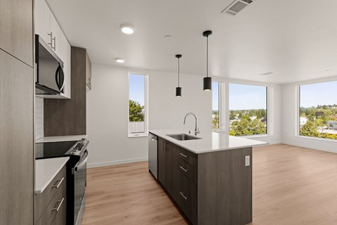A modern kitchen with wooden cabinets and a large window.
