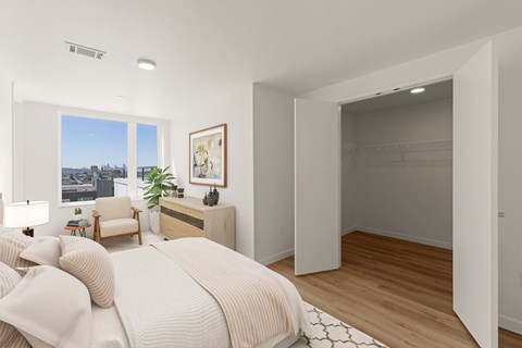 A bedroom with a large bed and a view of the city.