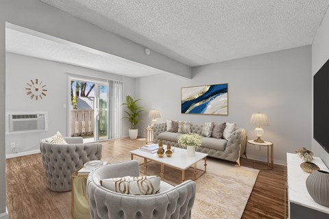 A living room with a grey couch, a white coffee table, and a painting on the wall.