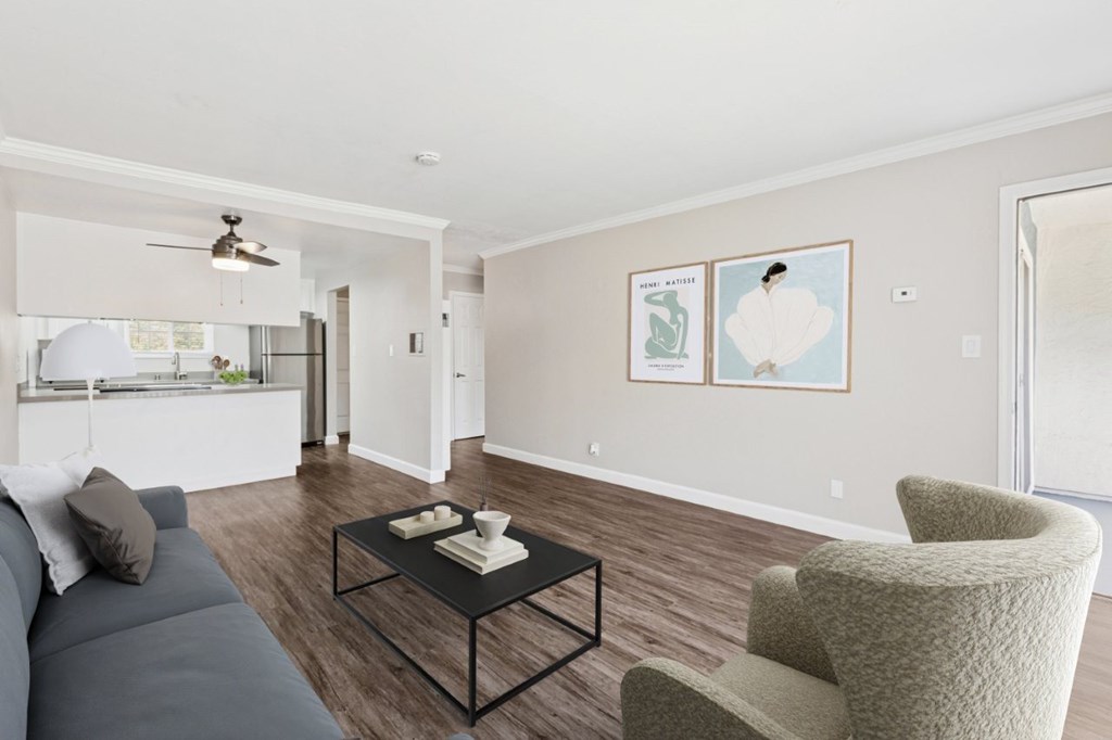 A living room with a grey couch, a black coffee table, and a beige armchair.