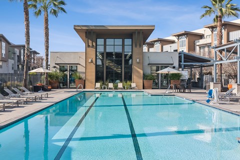 Aspire Apartments Tracy California Luxury Living A large swimming pool in front of a building with palm trees.