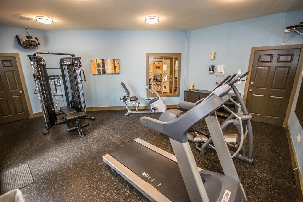a gym with weights and cardio equipment at Arnada Pointe apartments