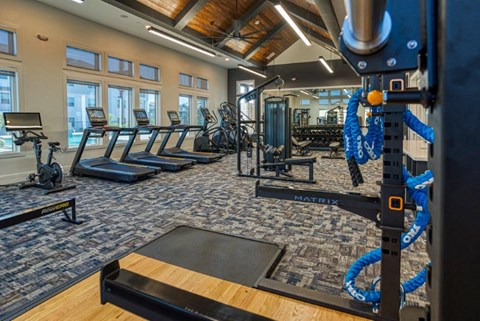 a gym with cardio equipment and a row of exercise machines
